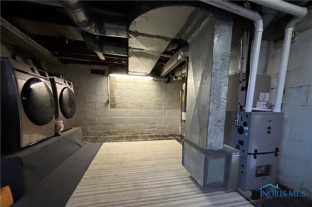 basement with heating unit and washer and clothes dryer