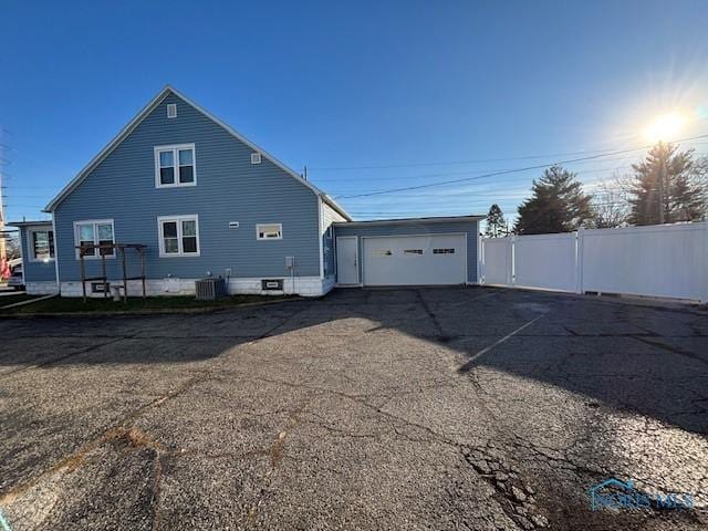 back of property with a garage, an outbuilding, and cooling unit