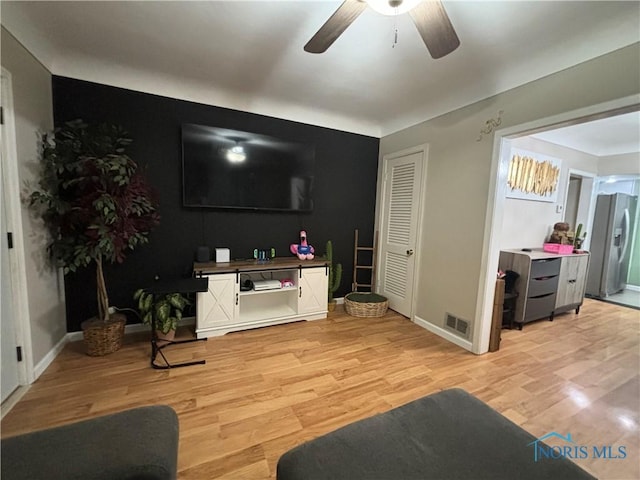 living room with ceiling fan and light wood-type flooring