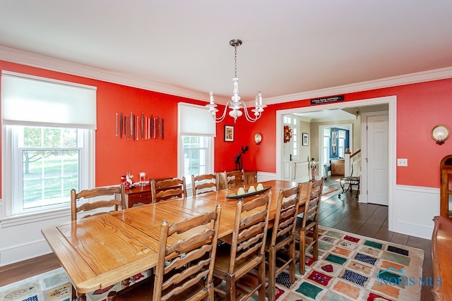 dining area featuring an inviting chandelier, crown molding, and dark hardwood / wood-style flooring