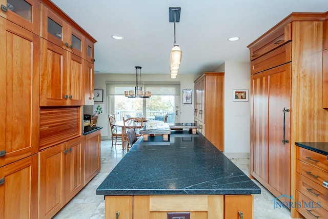 kitchen with dark stone counters, a center island, and pendant lighting