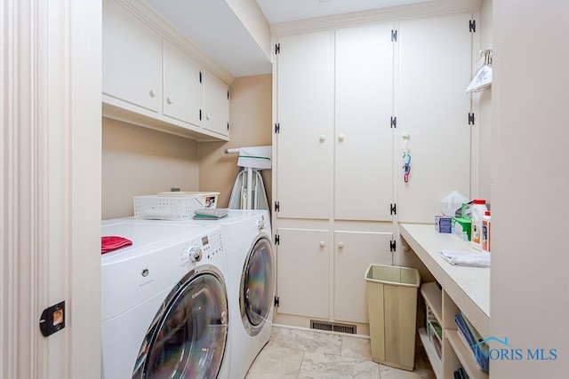 laundry area featuring washing machine and dryer and cabinets