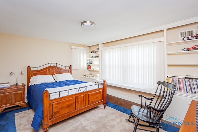 bedroom with light carpet and multiple windows