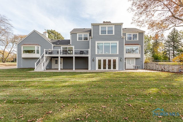 rear view of property with a wooden deck and a yard