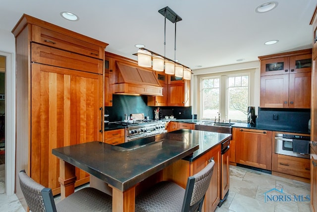 kitchen with tasteful backsplash, appliances with stainless steel finishes, a kitchen island, hanging light fixtures, and custom exhaust hood