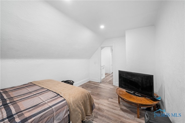 bedroom with lofted ceiling and hardwood / wood-style floors