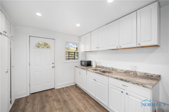 kitchen with sink, white cabinetry, and dark hardwood / wood-style floors