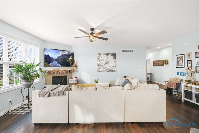 living room featuring dark wood-type flooring and ceiling fan