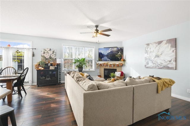 living room featuring dark wood-type flooring and ceiling fan