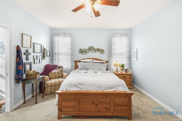 bedroom featuring multiple windows, light colored carpet, and ceiling fan