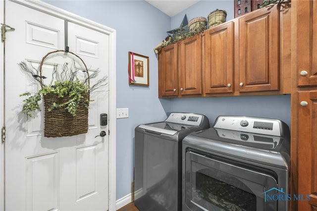 laundry area with washing machine and clothes dryer and cabinets