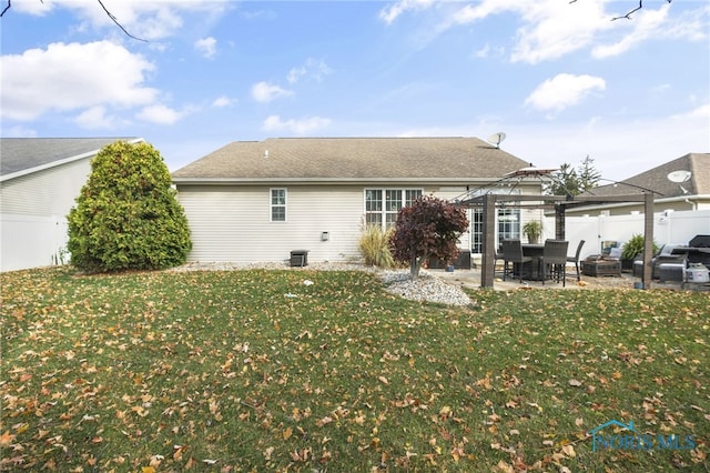 back of house featuring a patio area and a lawn