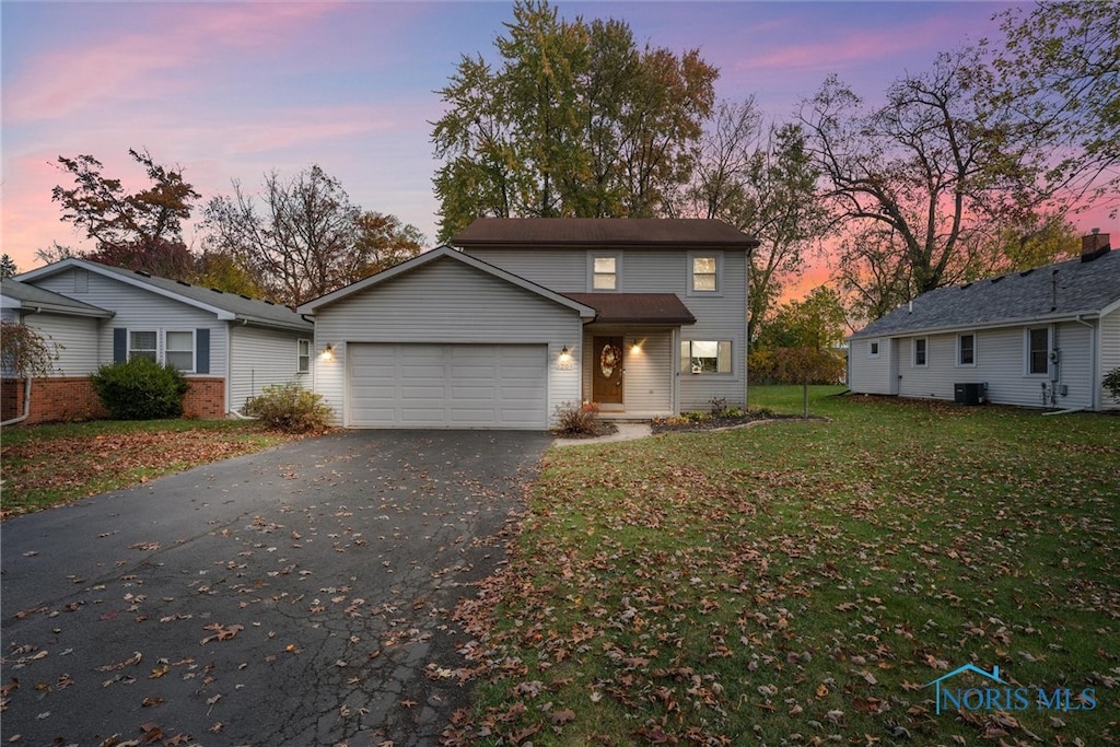 front of property with a lawn and a garage