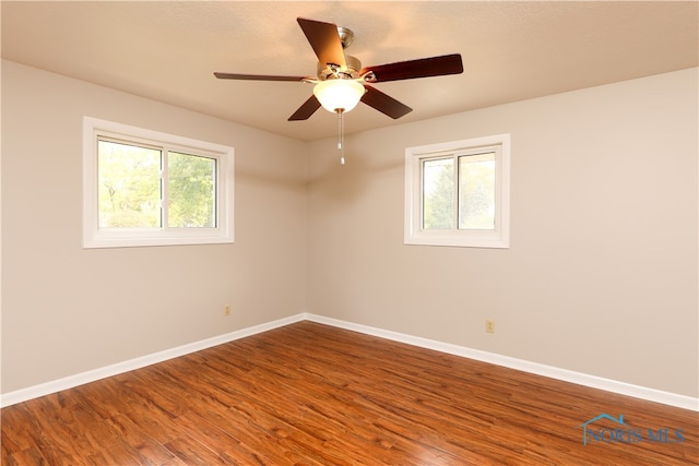 spare room featuring hardwood / wood-style flooring, a healthy amount of sunlight, and ceiling fan