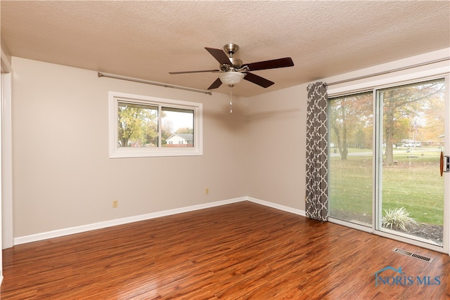 spare room with a textured ceiling, hardwood / wood-style flooring, and ceiling fan