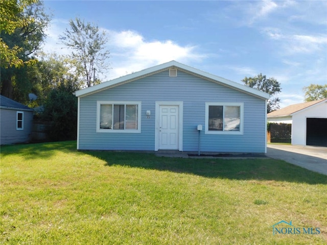 view of front of property with a front lawn, an outbuilding, and a garage