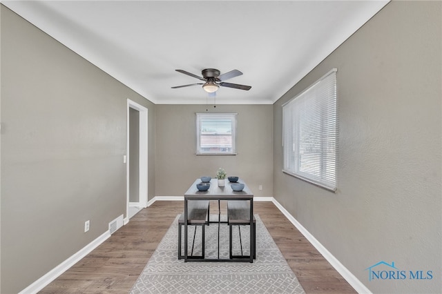 unfurnished dining area featuring ceiling fan and wood-type flooring