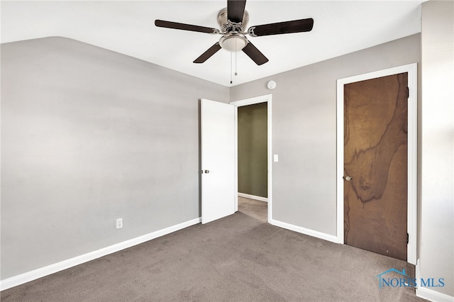 unfurnished bedroom featuring carpet floors, vaulted ceiling, and ceiling fan