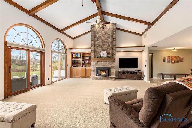 living room with high vaulted ceiling, ceiling fan, beamed ceiling, light colored carpet, and a fireplace