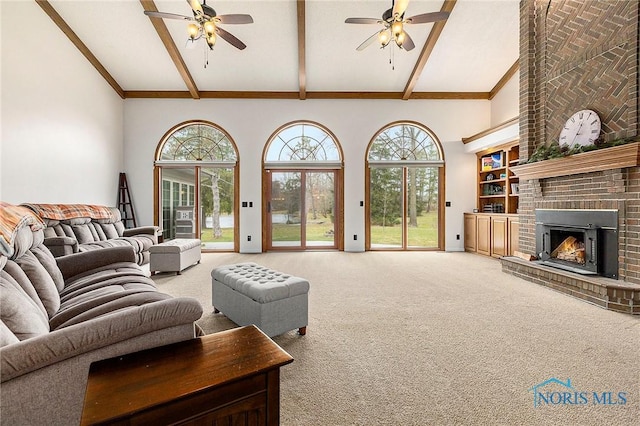 carpeted living room with beamed ceiling, ceiling fan, high vaulted ceiling, and a brick fireplace