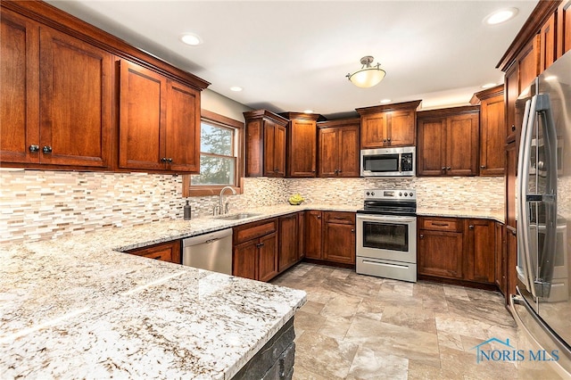 kitchen featuring backsplash, sink, light stone countertops, and stainless steel appliances