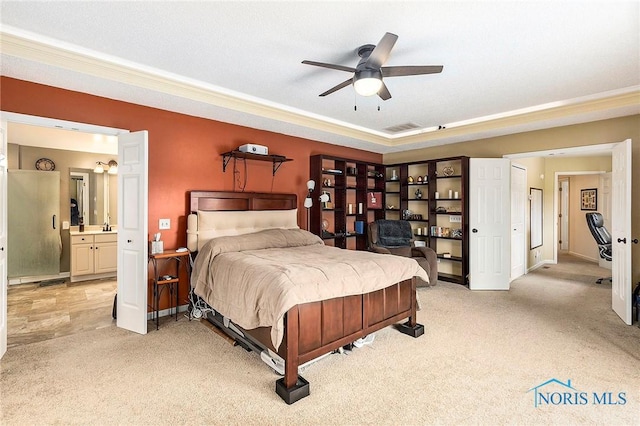 carpeted bedroom with ornamental molding, ceiling fan, and ensuite bath