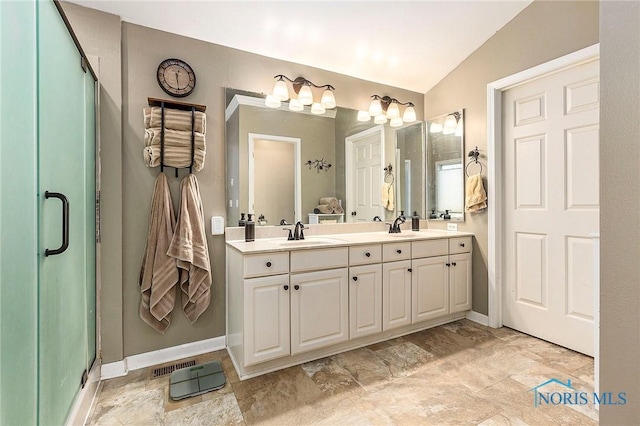 bathroom with vanity, a shower with shower door, and lofted ceiling