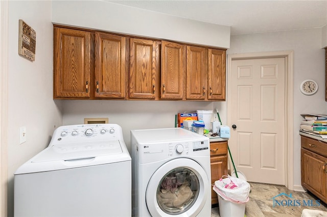 clothes washing area featuring washer and clothes dryer and cabinets