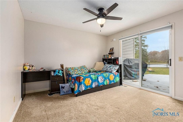 carpeted bedroom with access to exterior, a textured ceiling, and ceiling fan