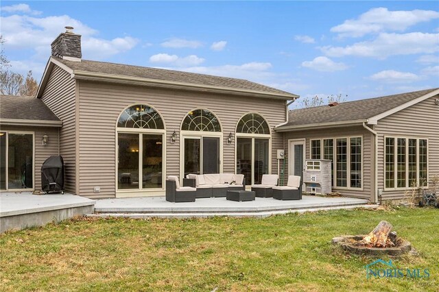 back of property with outdoor lounge area, a yard, and a patio