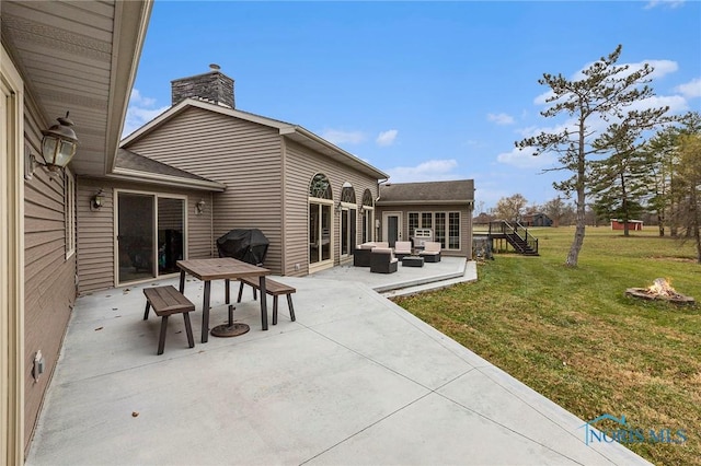 exterior space featuring a patio, an outdoor structure, outdoor lounge area, and a lawn