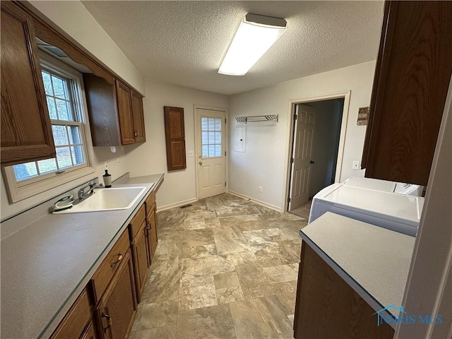 kitchen with separate washer and dryer, sink, and a textured ceiling