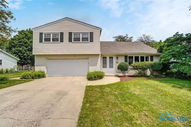 view of front of property featuring a front lawn and a garage