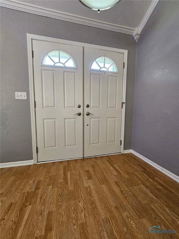 foyer featuring hardwood / wood-style flooring and crown molding