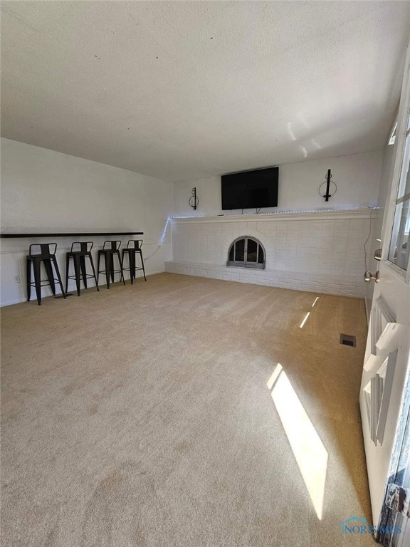 living room featuring plenty of natural light, carpet, and a textured ceiling