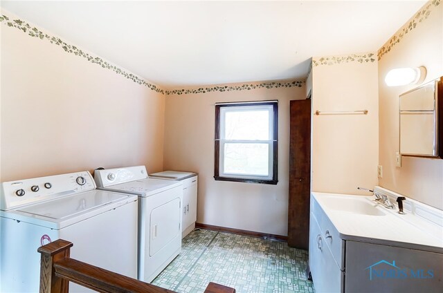 clothes washing area with cabinets, sink, and independent washer and dryer