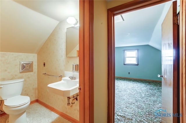 bathroom with lofted ceiling, sink, and toilet