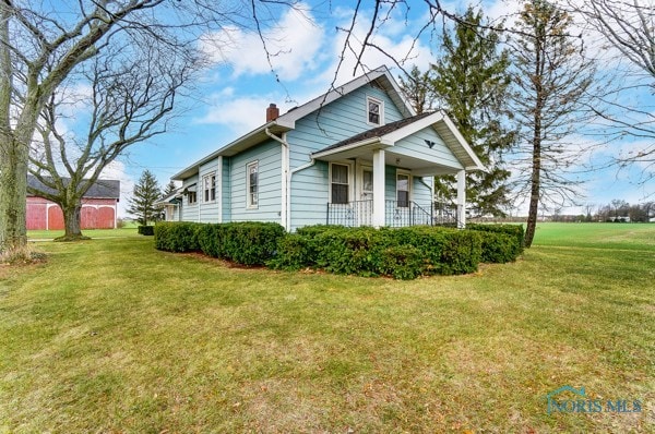 view of home's exterior with a lawn and covered porch