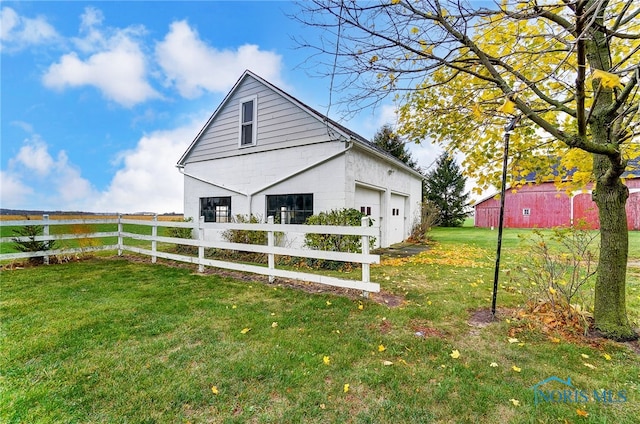 view of home's exterior featuring a garage, a lawn, and an outbuilding