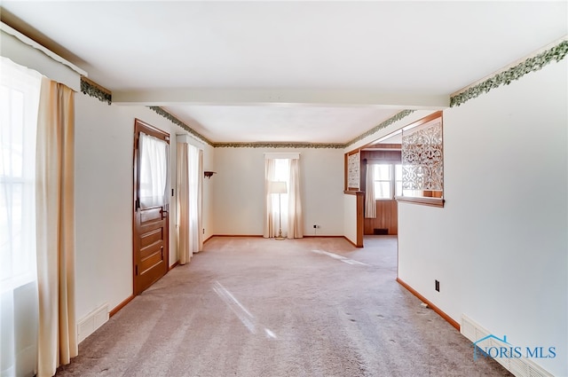 carpeted spare room with beam ceiling