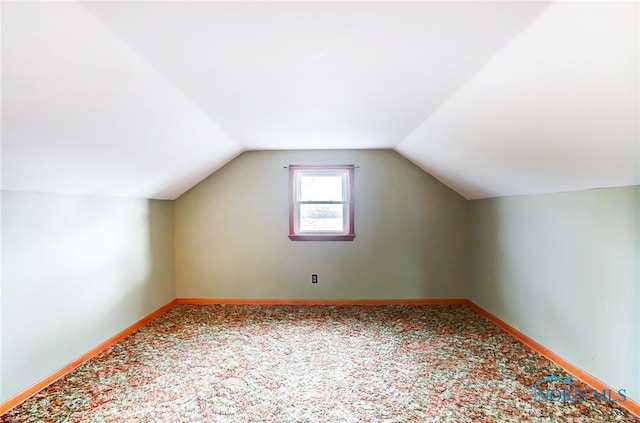 additional living space featuring lofted ceiling and carpet