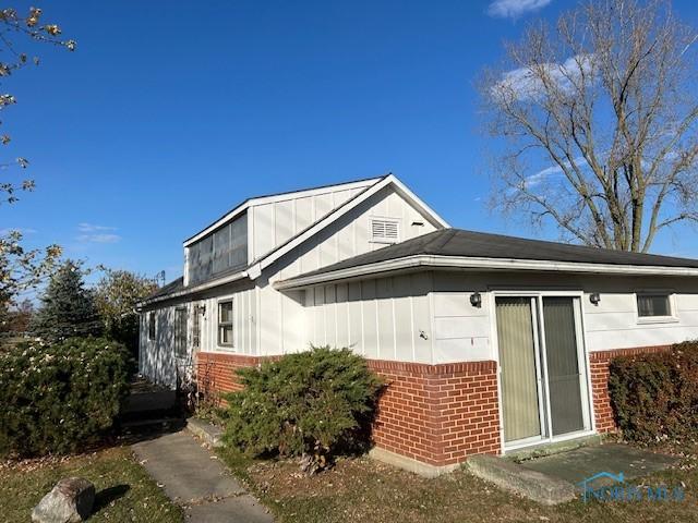 1811 E Wilson, Bryan, OH 43506 - view of side of property featuring board and batten siding and brick siding