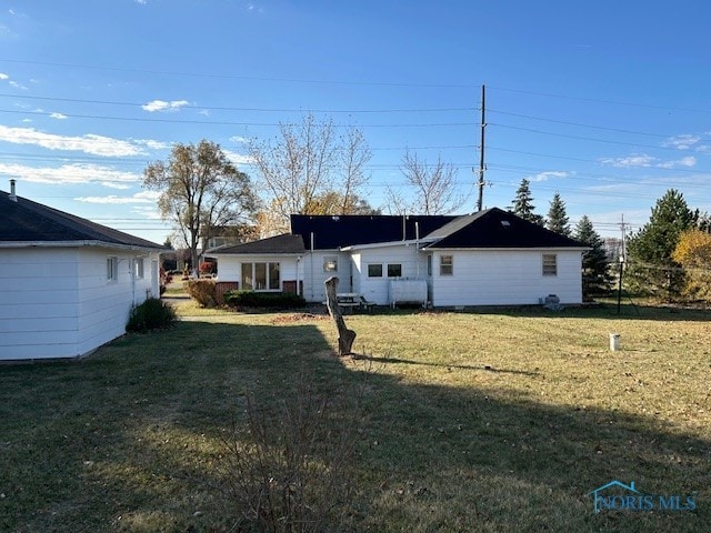 back of property featuring a lawn