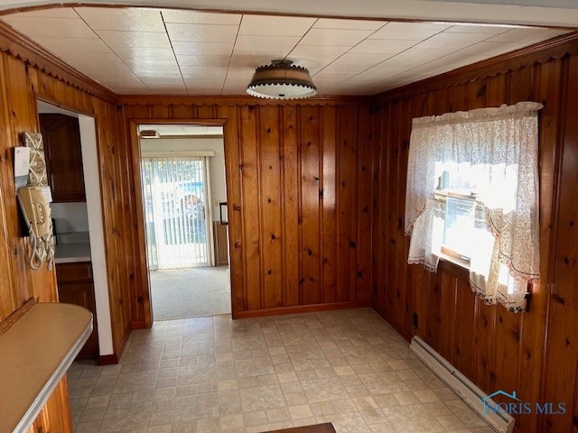 interior space with baseboard heating and wood walls