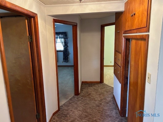 corridor with dark carpet and ornamental molding