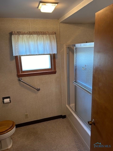 bathroom featuring shower / bath combination with glass door and toilet