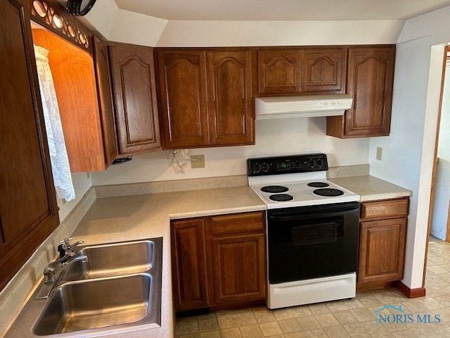 kitchen with electric stove, vaulted ceiling, and sink