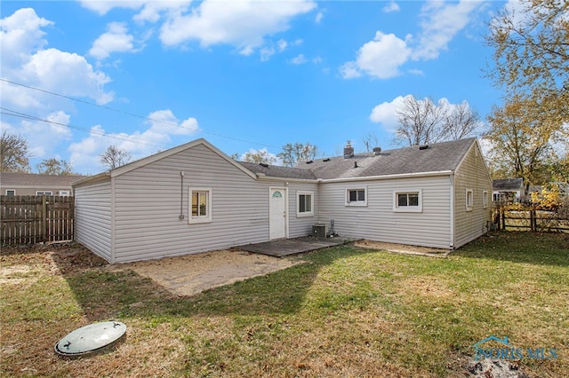 back of house with a patio area and a lawn