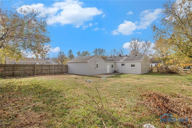 rear view of property featuring a lawn