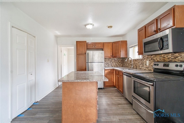 kitchen with decorative backsplash, dark hardwood / wood-style flooring, stainless steel appliances, sink, and a center island